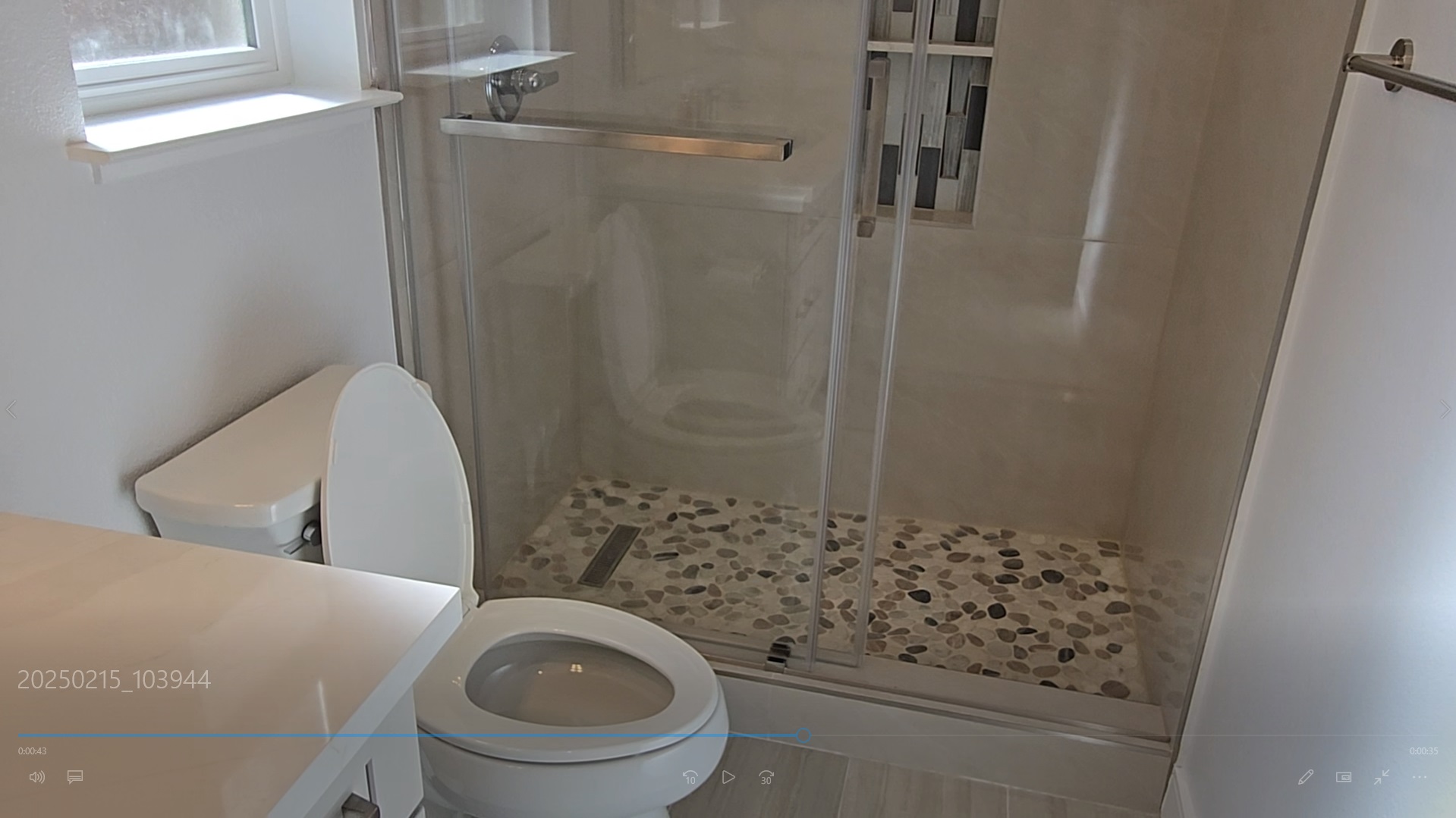 Bathroom Toilet and Stone-Tiled Shower Floor