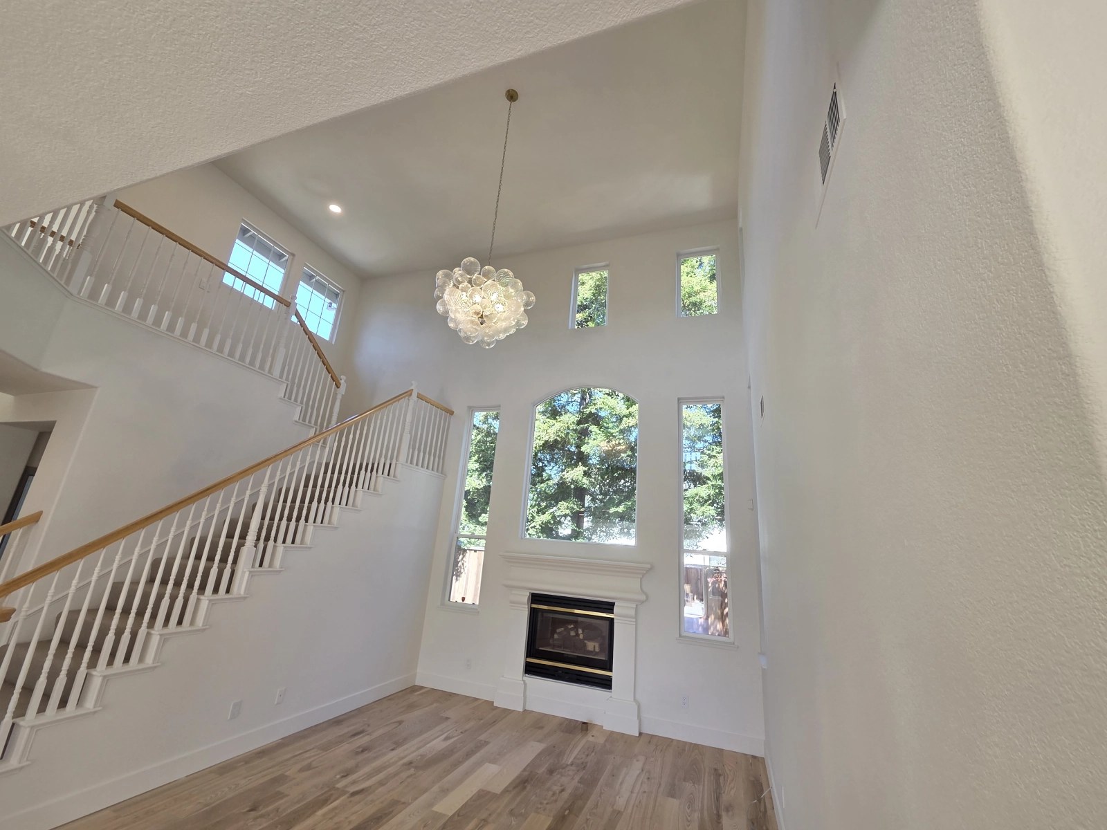 9Builders: Elegant Staircase and Open Living Room with Fireplace