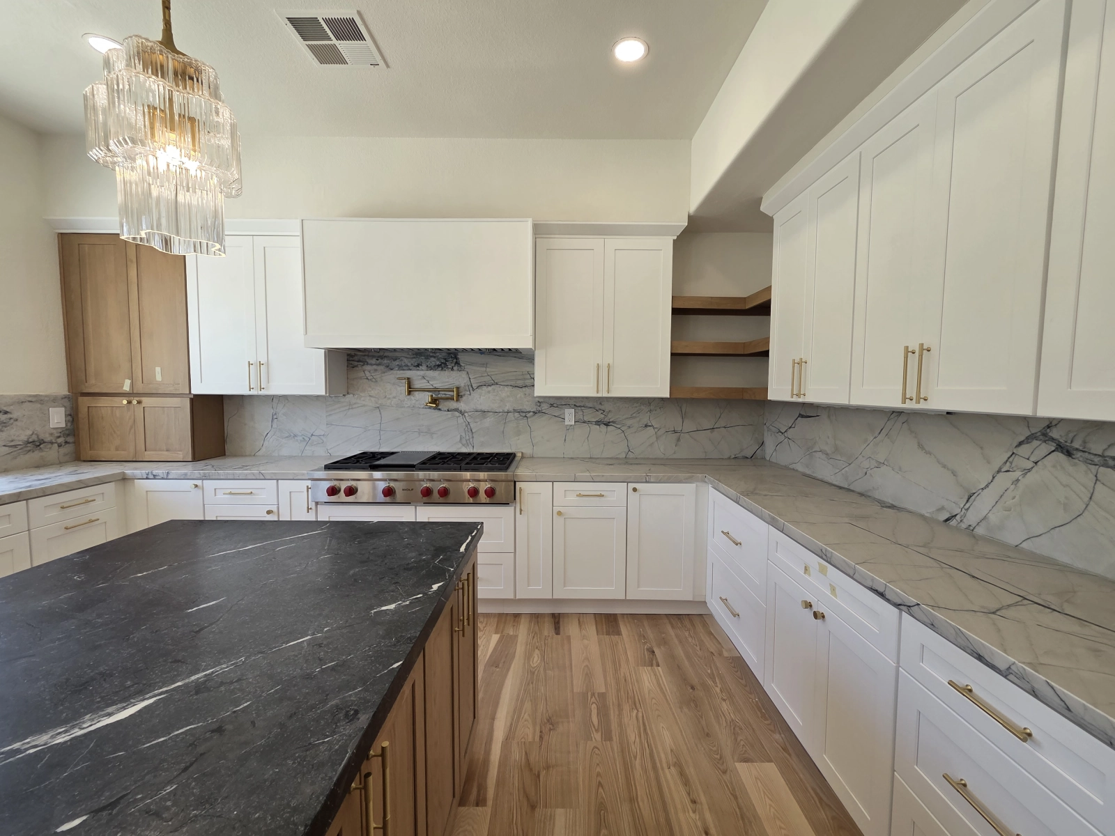 9Builders: Spacious Kitchen with Elegant Lighting and Marble Countertops