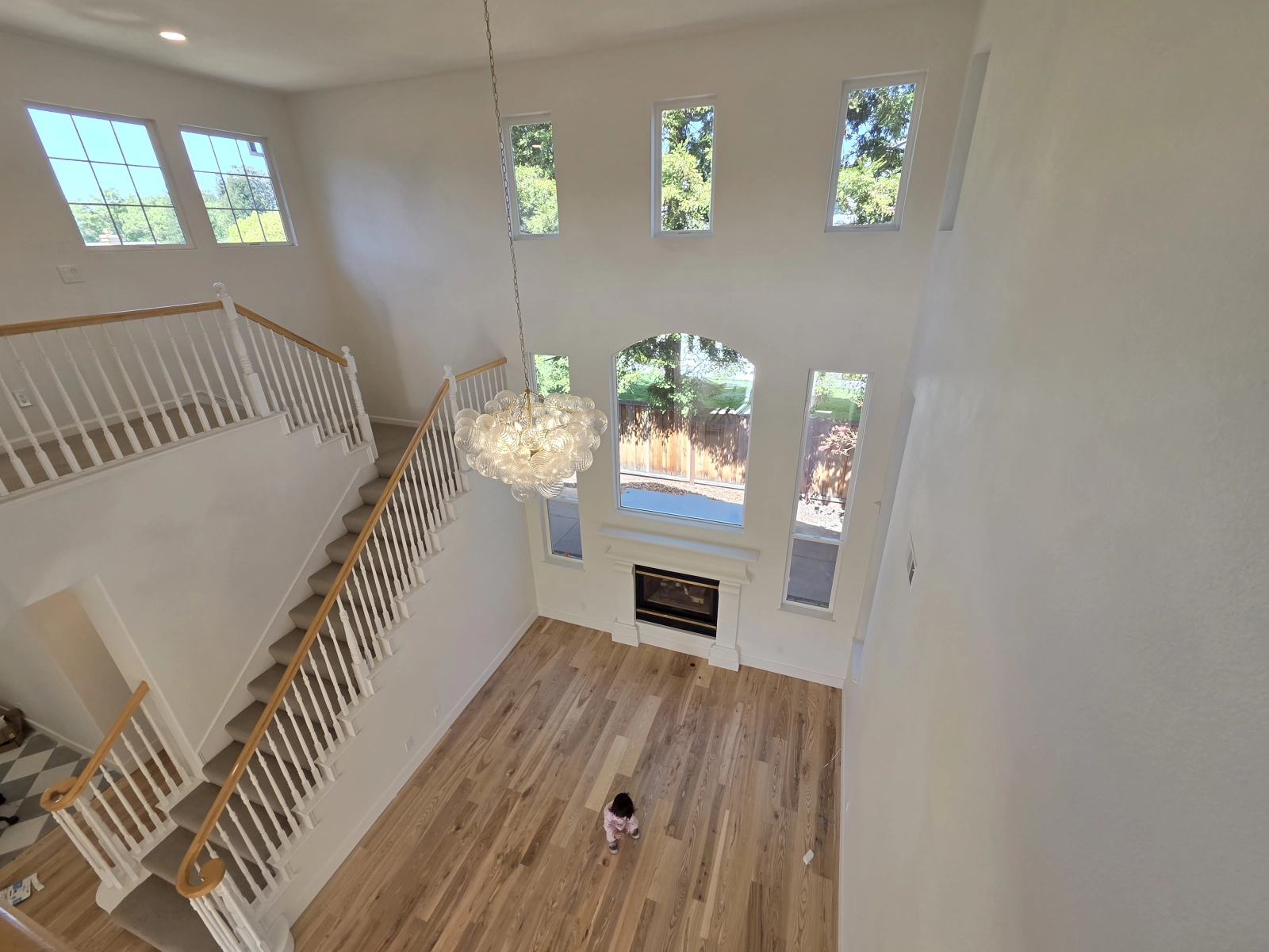 9Builders: Elegant Staircase and Custom Lighting in a Bright Entryway