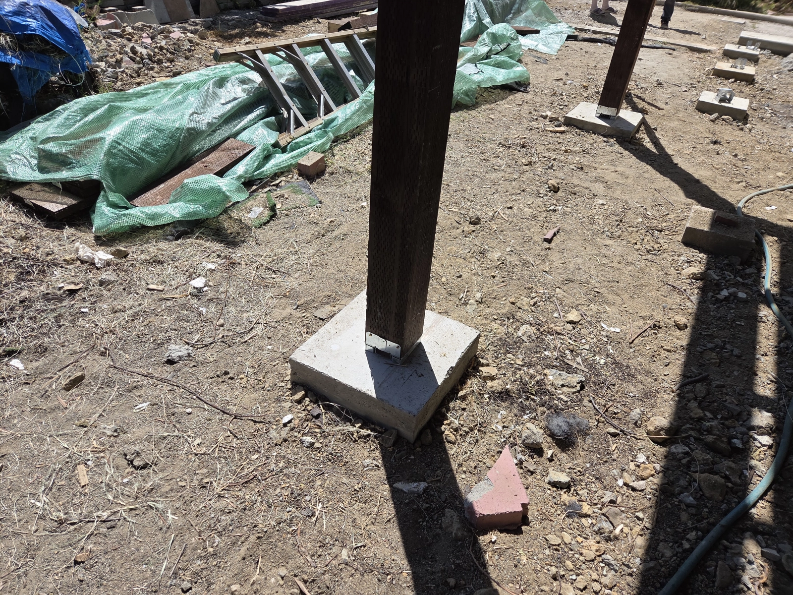 Close-up of wood post secured to concrete base